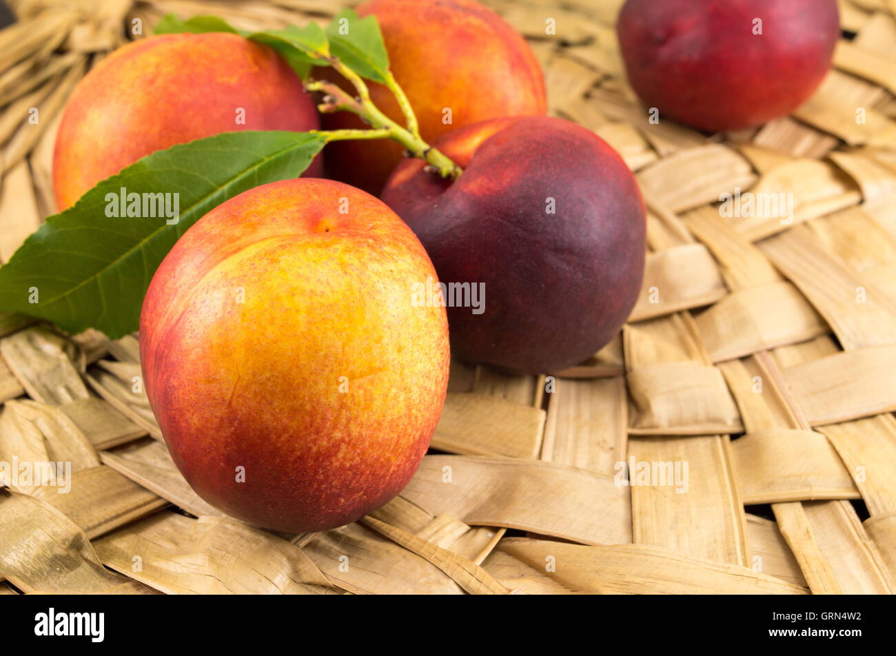 Frische rohe Pfirsiche auf Holzoberfläche wicker Stockfoto