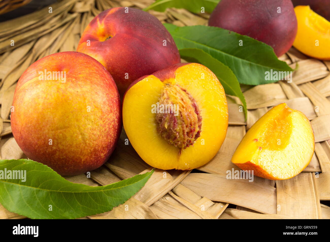 Frische rohe Pfirsiche auf Holzoberfläche wicker Stockfoto