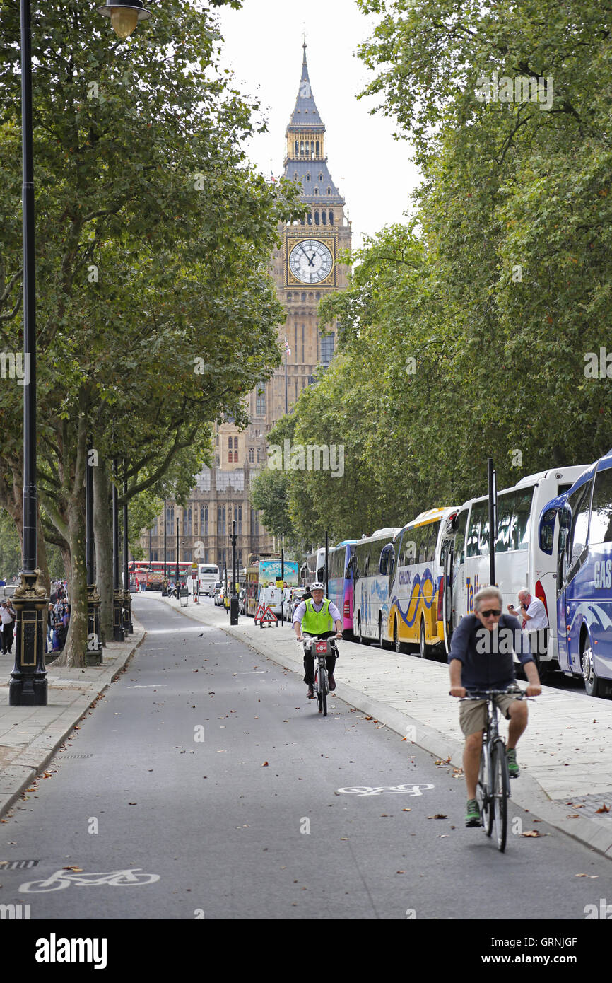 Radfahrer nutzen Londons neue getrennten Radweg am Victoria Embankment, an der Themse. Big Ben im Hintergrund. Stockfoto