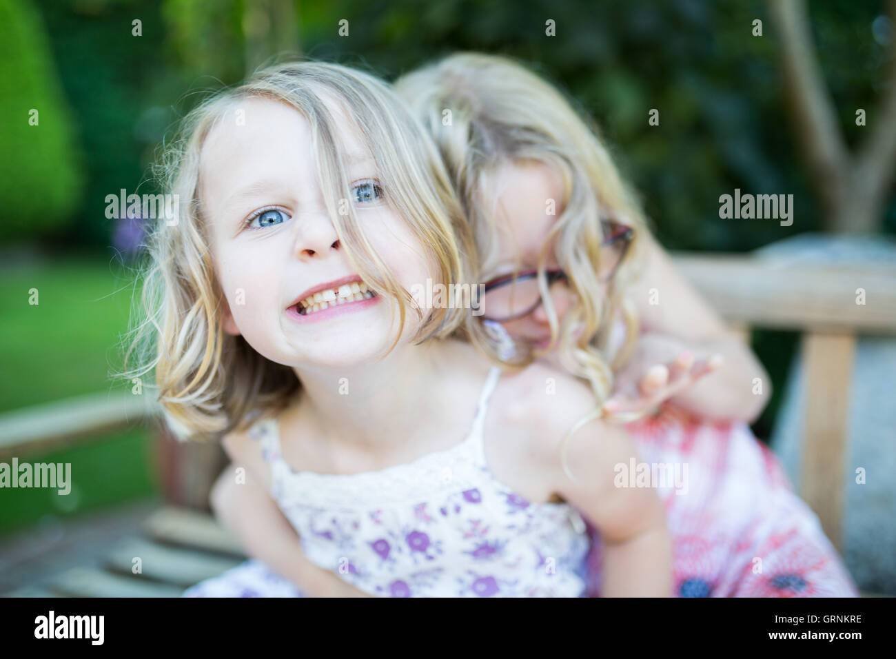 zwei Mädchen auf einer Bank herumfummeln Stockfoto