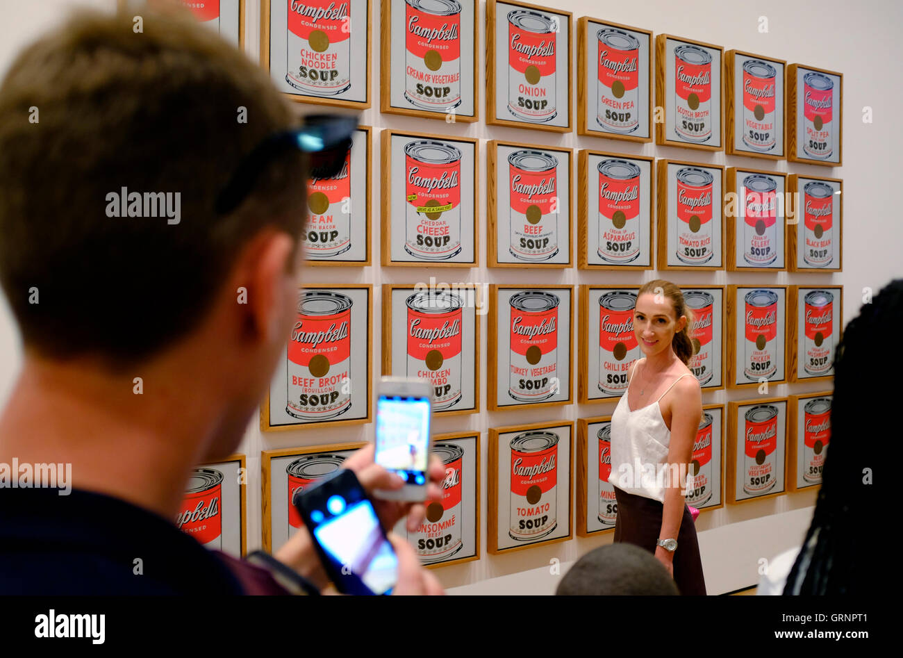 Besucher, die die Handy Fotos von Campbells Soup Cans (1962) von Andy Warhol im Museum of Modern Art (MoMA), New York City, USA Stockfoto