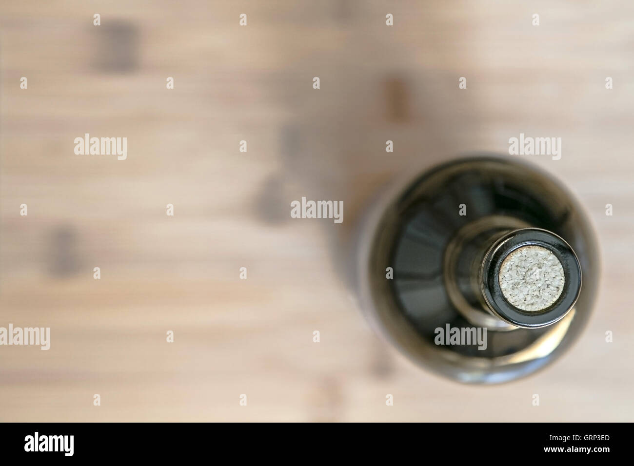 Stillleben mit einer Flasche Wein auf einer Holzfläche steht unscharf Hintergrund, Ansicht von oben. Stockfoto
