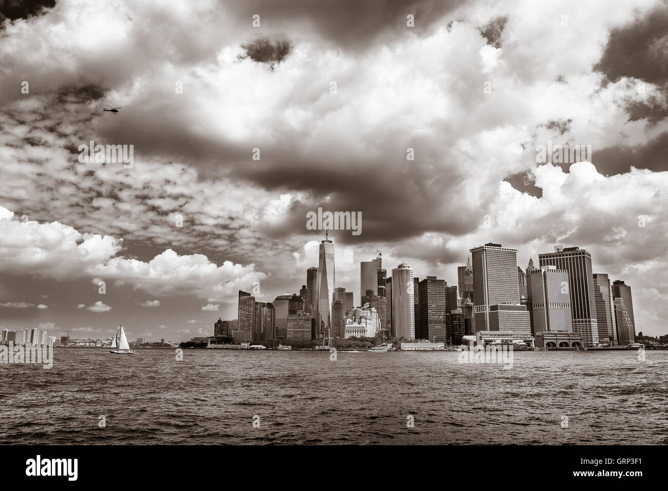 Im Hafen von New York mit dem Bürogebäude von lower Manhattan im Hintergrund ist ein kleines Segelboot Kreuzfahrt. Stockfoto