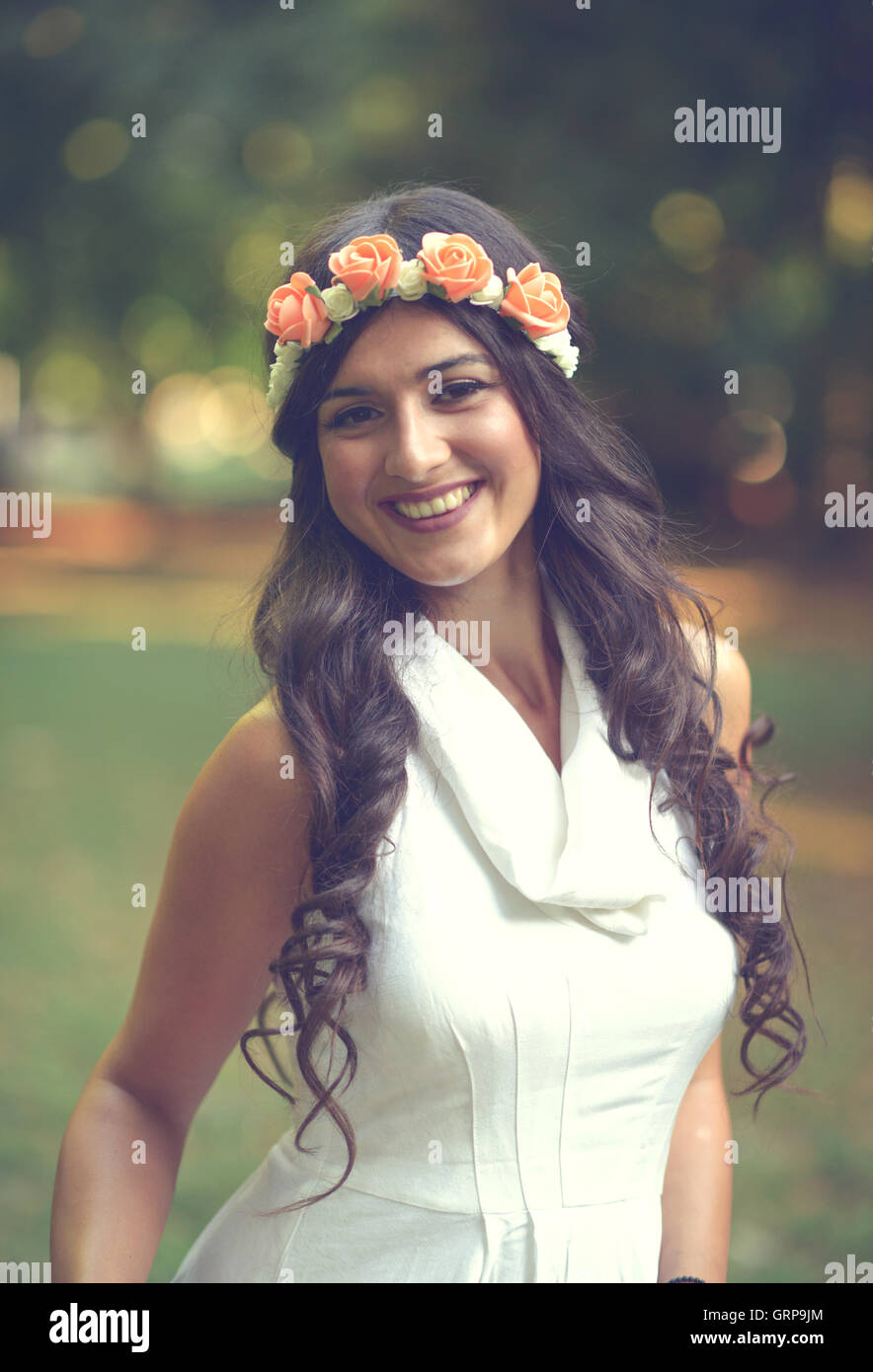 Porträt der schönen jungen Frau mit Blumenkranz in der Natur Stockfoto