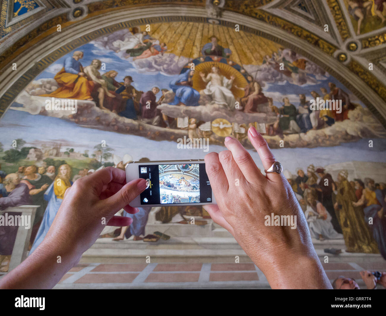 Ein Tourist in der Raphael-Zimmer im Vatikan Aufnahme eines Fotos auf einem Smartphone Stockfoto