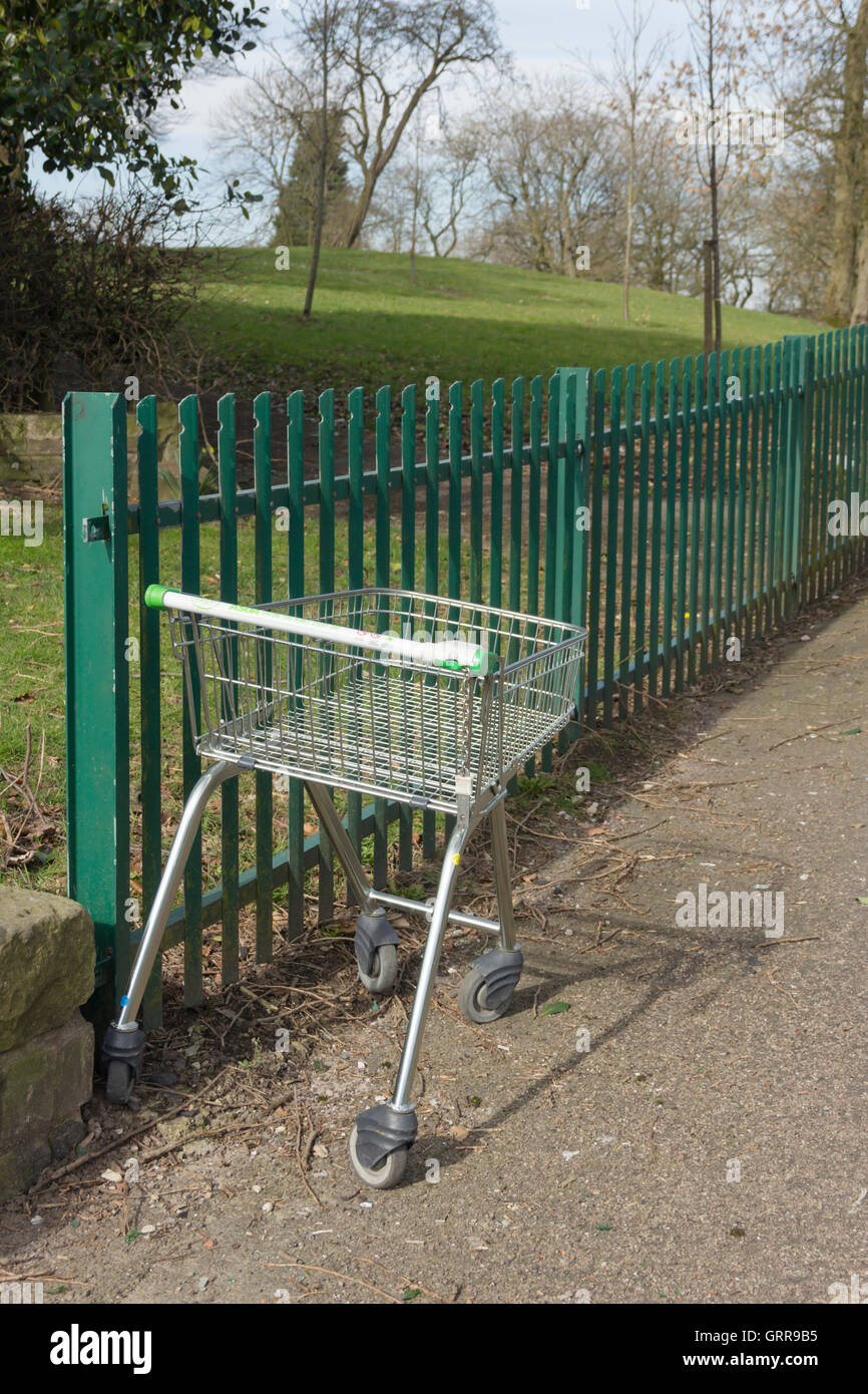 Ein Einkaufswagen ASDA aufgegeben einiger Entfernung aus dem Supermarkt in der Nähe einen Eingang zum Central Park Farnworth, Bolton. Stockfoto