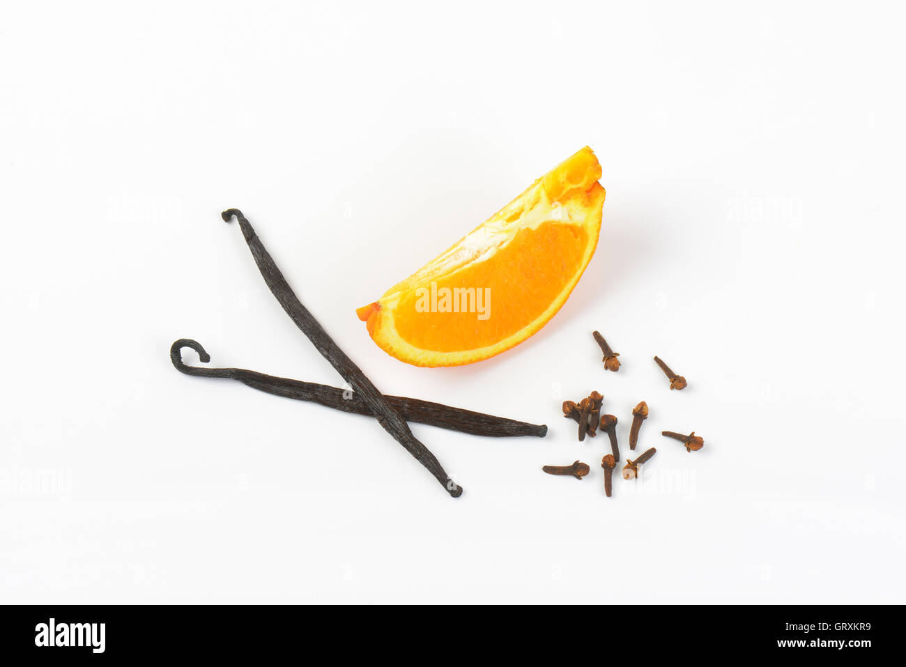 Orangenscheibe, Vanilleschoten und Nelken auf weißem Hintergrund Stockfoto