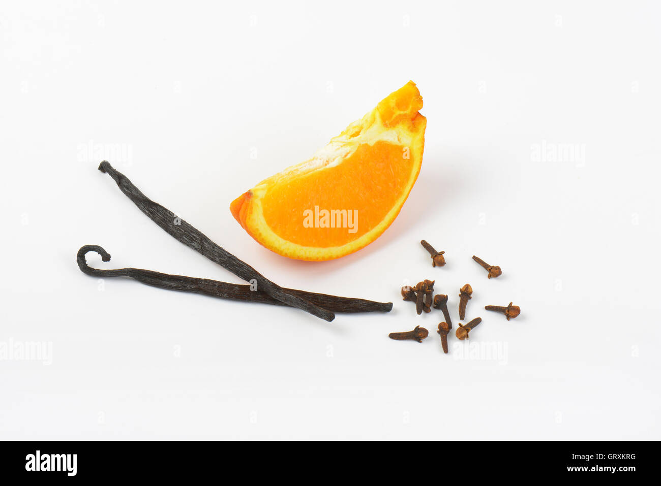 Orangenscheibe, Vanilleschoten und Nelken auf weißem Hintergrund Stockfoto