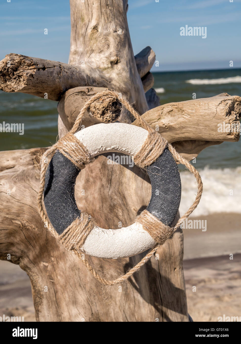 Rettungsring hing an den getrockneten Baumstamm stecken in den Strand Stockfoto