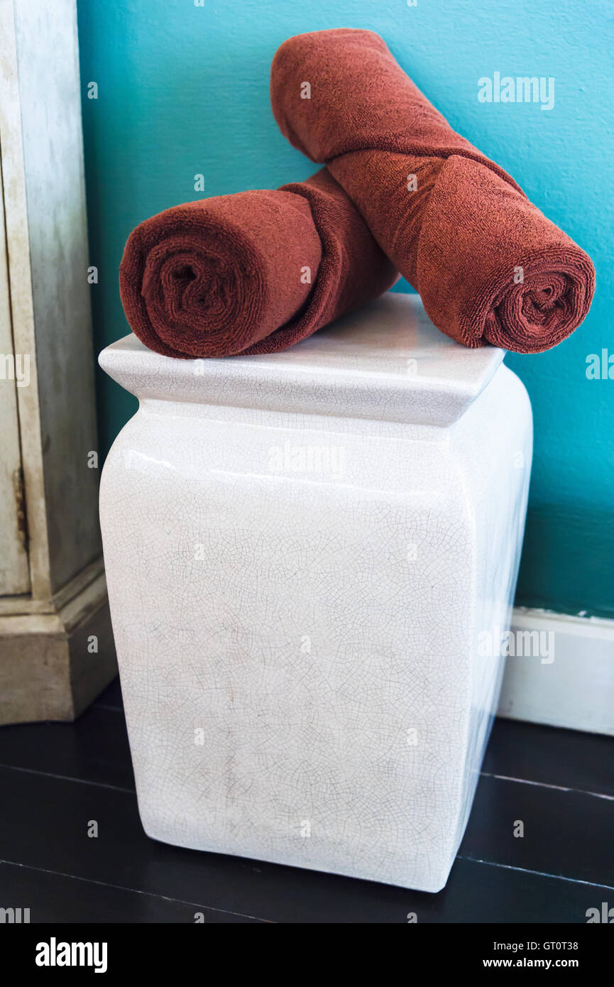 braune Handtücher auf weißen Stuhl im Zimmer Stockfoto
