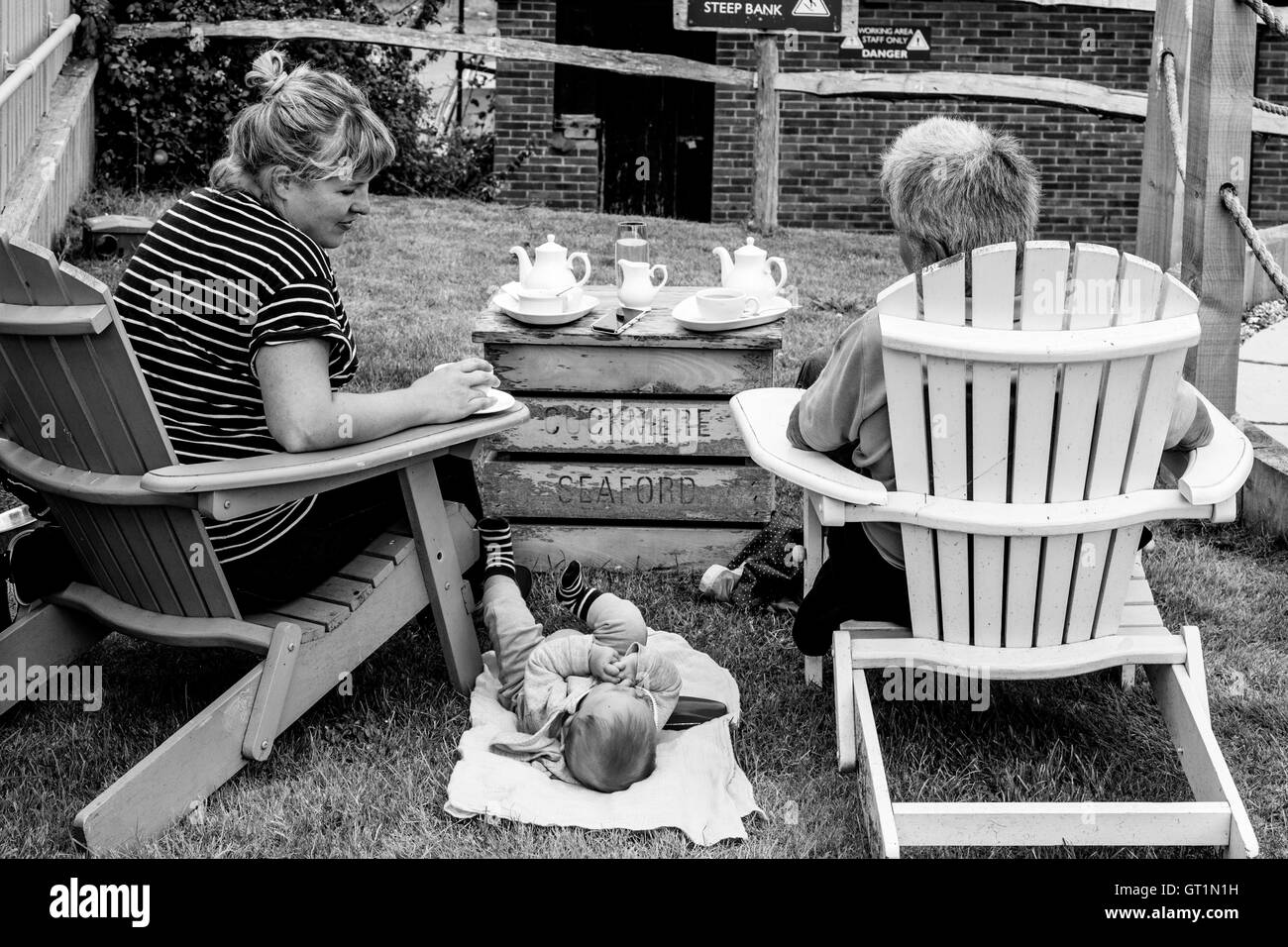 Eine Familie, genießen Sie eine Tasse Tee In einem Pub Garden, Sussex, Großbritannien Stockfoto