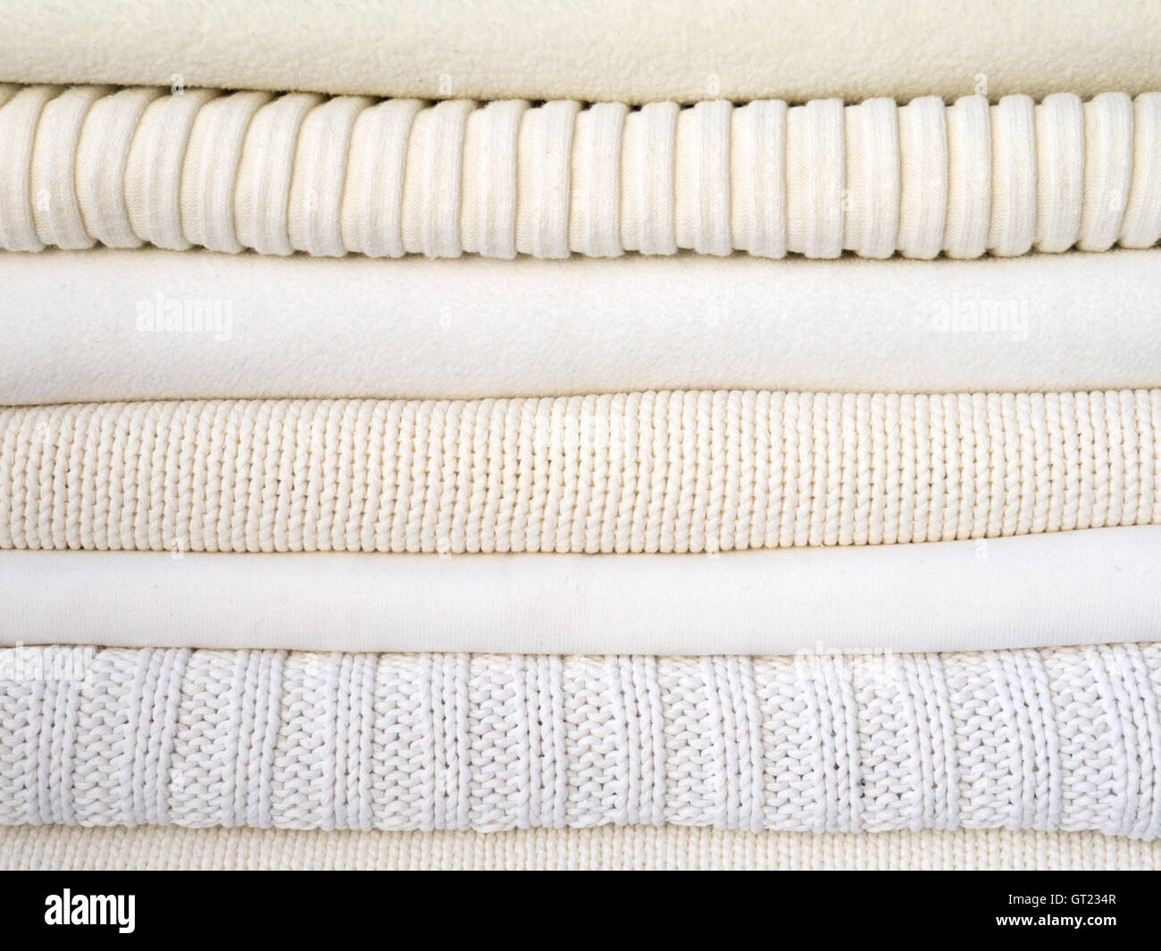 Stapel von warmen weißen Kleidern mit verschiedenen Texturen Stockfoto