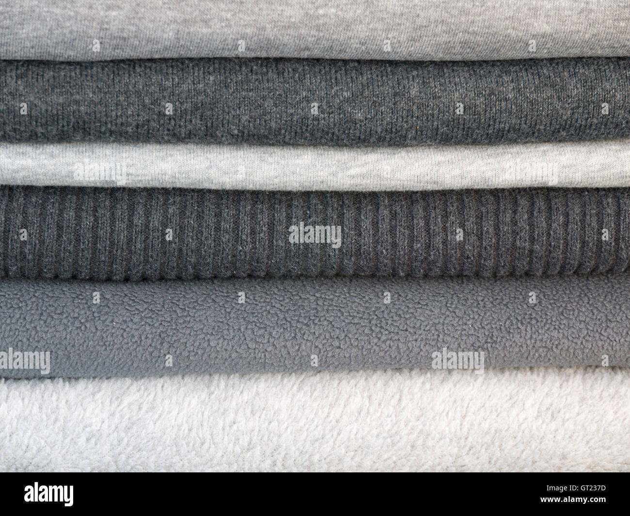 Stapel von Winterkleidung in verschiedenen Schattierungen von grau Stockfoto