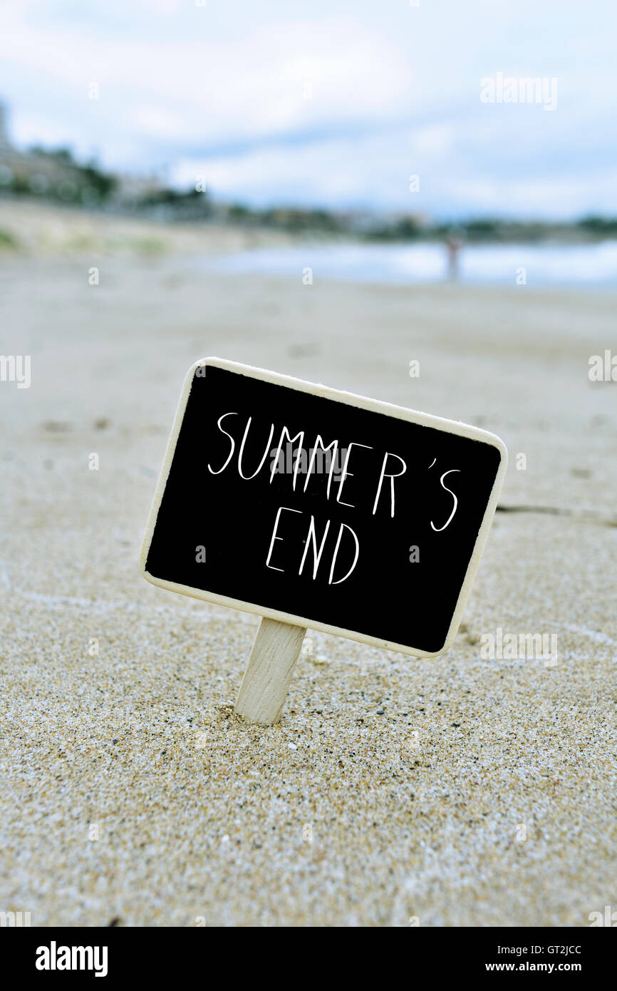 Nahaufnahme von einem schwarzen Schild mit dem Text Sommern Ende geschrieben, auf dem Sand des Strandes Stockfoto