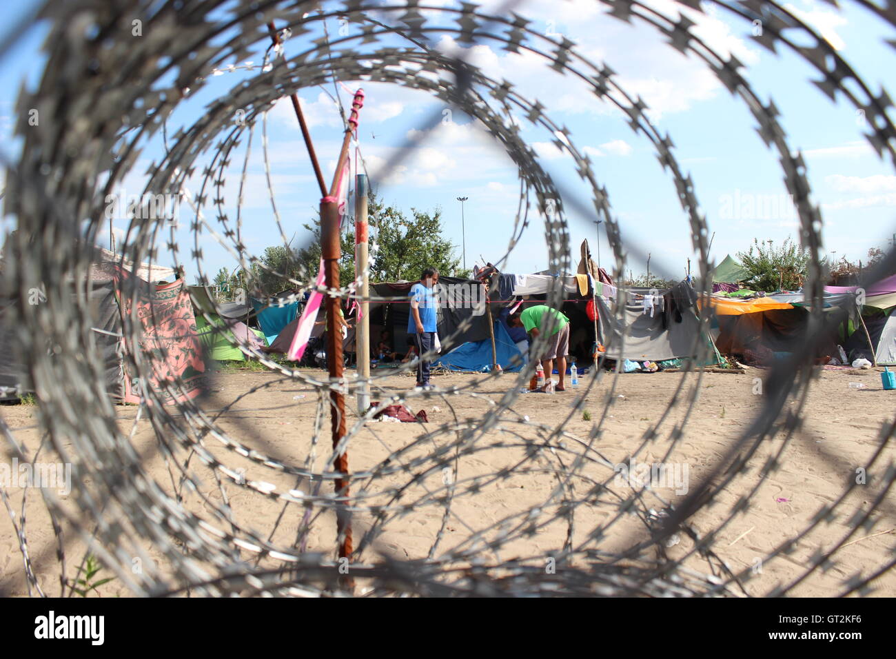 Der Zaun an der Ungarisch-serbischen Grenze mit einem behelfsmäßigen Flüchtlingslager auf der serbischen Seite. Stockfoto