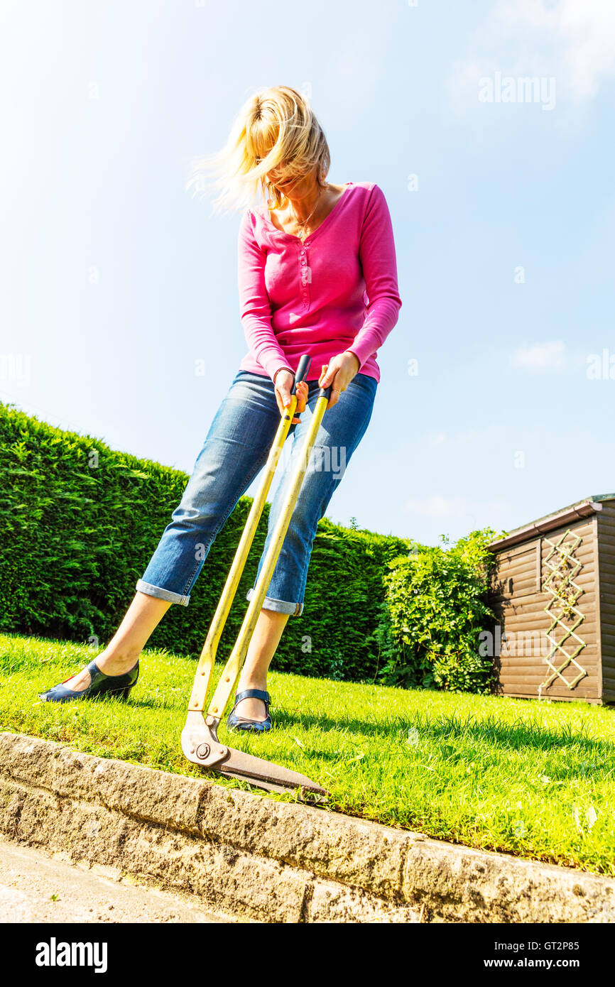 Mäht Rasen mit langstieligen Scheren Scheren trimmen Rand Frau Gartenbau Gärtner Hecke schneiden UK England GB Einfassung Stockfoto