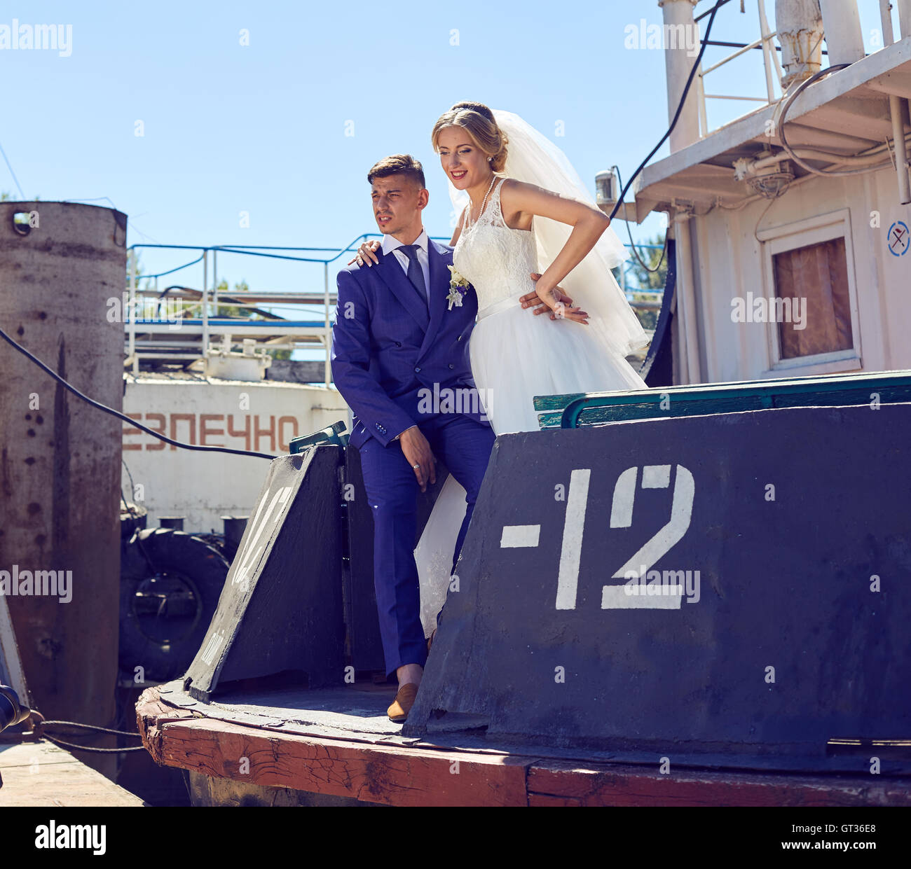 Paar in Hochzeitskleidung mit einem Strauß Blumen auf dem Boot Stockfoto