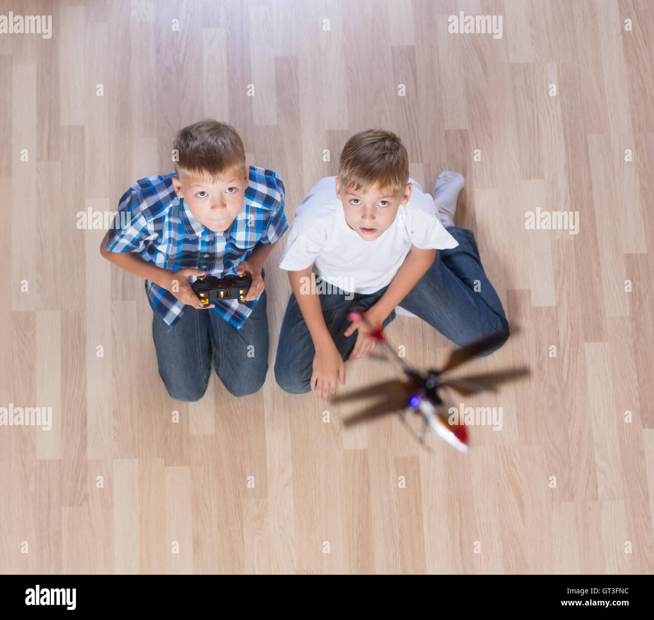 Jungs spielen mit fliegenden Hubschrauber-Modell zu Hause mittels Fernbedienung Stockfoto