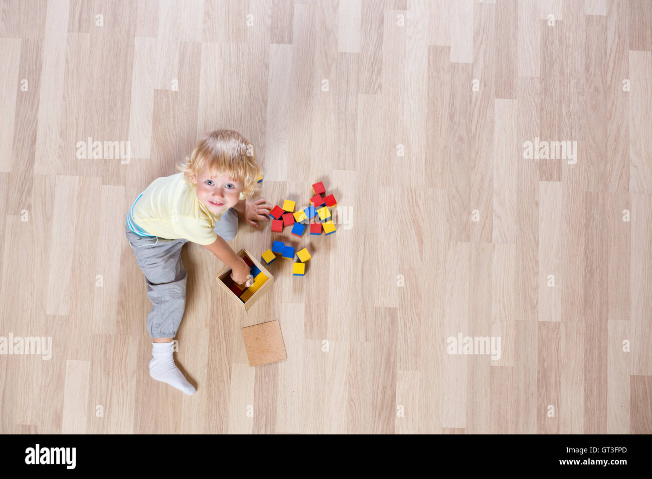 Kind spielt mit bunten Spielzeug Boden Draufsicht Stockfoto