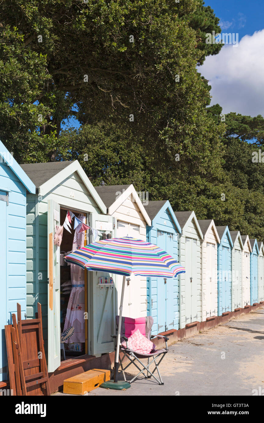 Sonnenschirm- und Strandhütten an einem warmen, sonnigen Tag am Avon Beach, Mudeford, Christchurch, Dorset UK im September Stockfoto