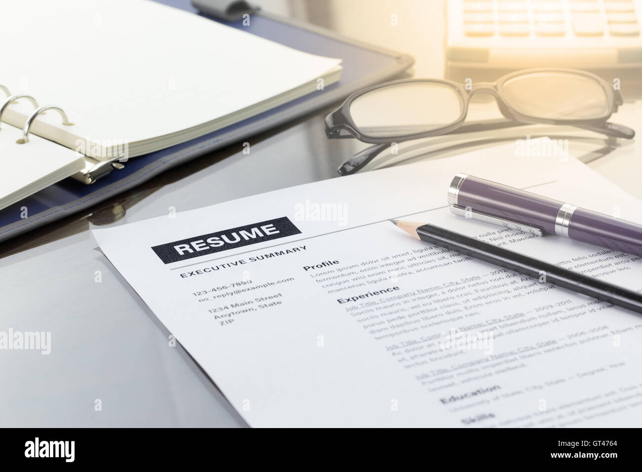 Lebenslauf mit Kugelschreiber, Bleistift, Taschenrechner, Notizbuch und Gläser. Stockfoto