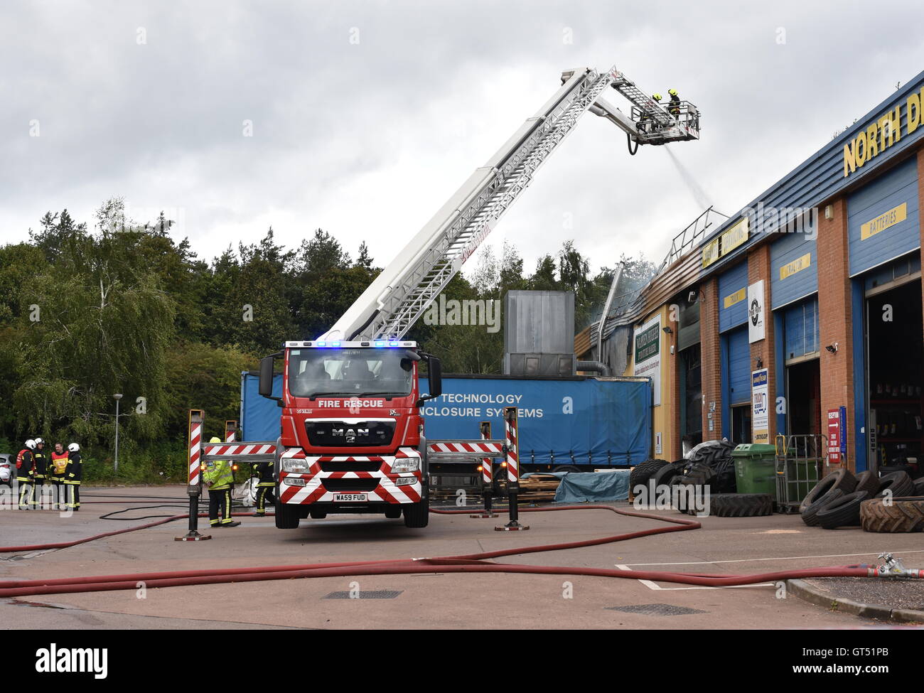 Devon, UK. 9. September 2016. Tiverton Feuer: Die Szene von einem Großbrand in den Räumlichkeiten des Warren Hughes Möbelhersteller in Ormidale Square, Tiverton Business Park, Devon, am 16.00 BST auf Freitag, 9. September 2016. Die Feuerwehr wurden bei 11,23 genannt. Fünf Stunden waren später mindestens 6 Feuerlöschfahrzeuge noch am Tatort, darunter zwei Hebebühnen. Personal in den benachbarten Einheiten wurden auch unter anderem die Räumlichkeiten der North Devon Reifen und nationalen Reifen & Autocare evakuiert. Bildnachweis: Tim Squires/Alamy Live-Nachrichten Stockfoto