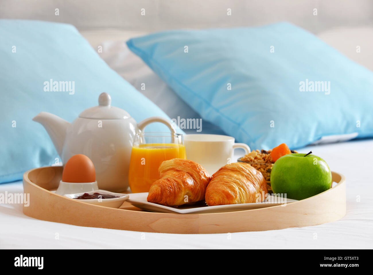 Frühstück auf Tablett im Bett im Hotelzimmer. Stockfoto