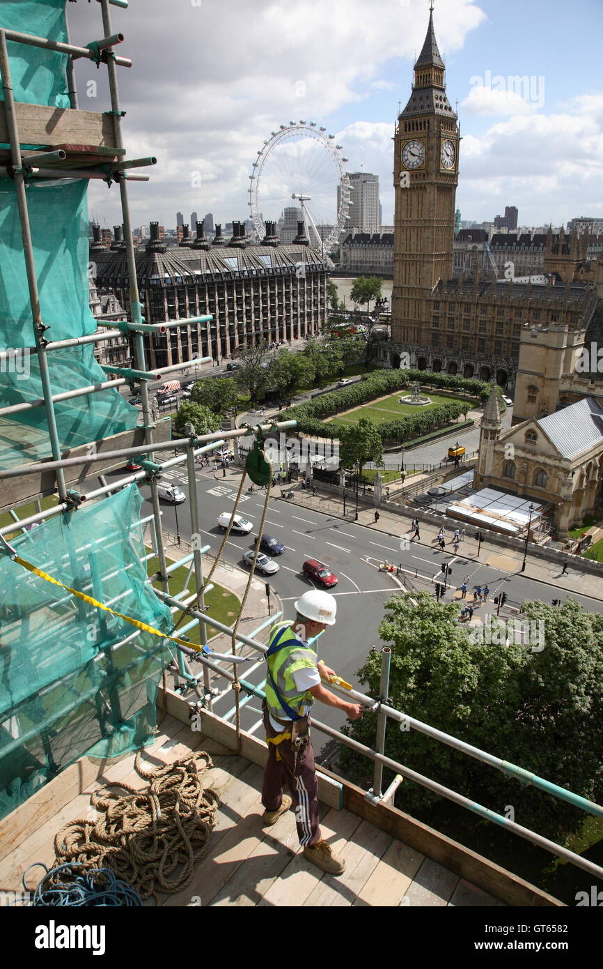 Eine junge Gerüstbauer arbeitet an Westminster Abbey mit Blick auf das London Eye, Big Ben und Parliament Square Stockfoto