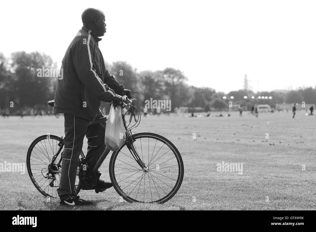 Ein Radfahrer blickt auf eine über die Sümpfe - Hackney & Leyton Sunday League Football im Süden Marsh, Hackney Sümpfe, London - 25.09.11 Stockfoto