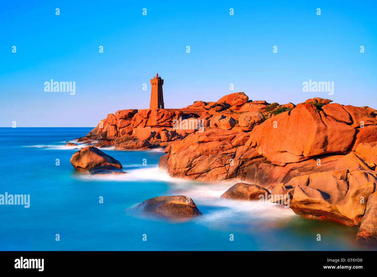 Ploumanach bedeuten Ruz Leuchtturm Roter Sonnenuntergang in rosa Granit Küste, Perros Guirec, Bretagne, Frankreich. Langzeitbelichtung. Stockfoto