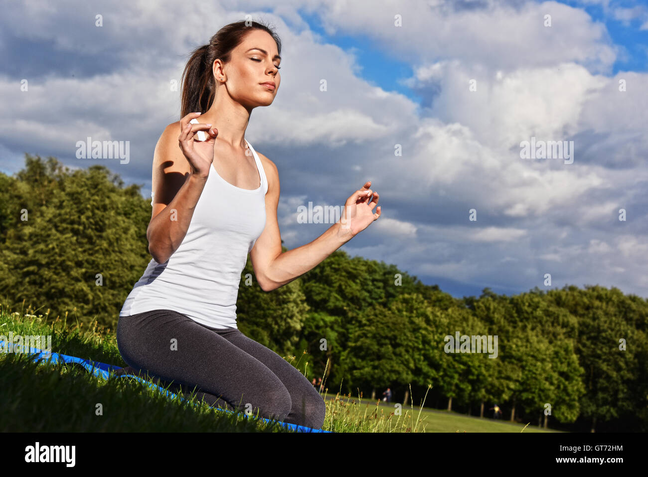 Junge Frau während der Yoga-Meditation im Park. Stockfoto