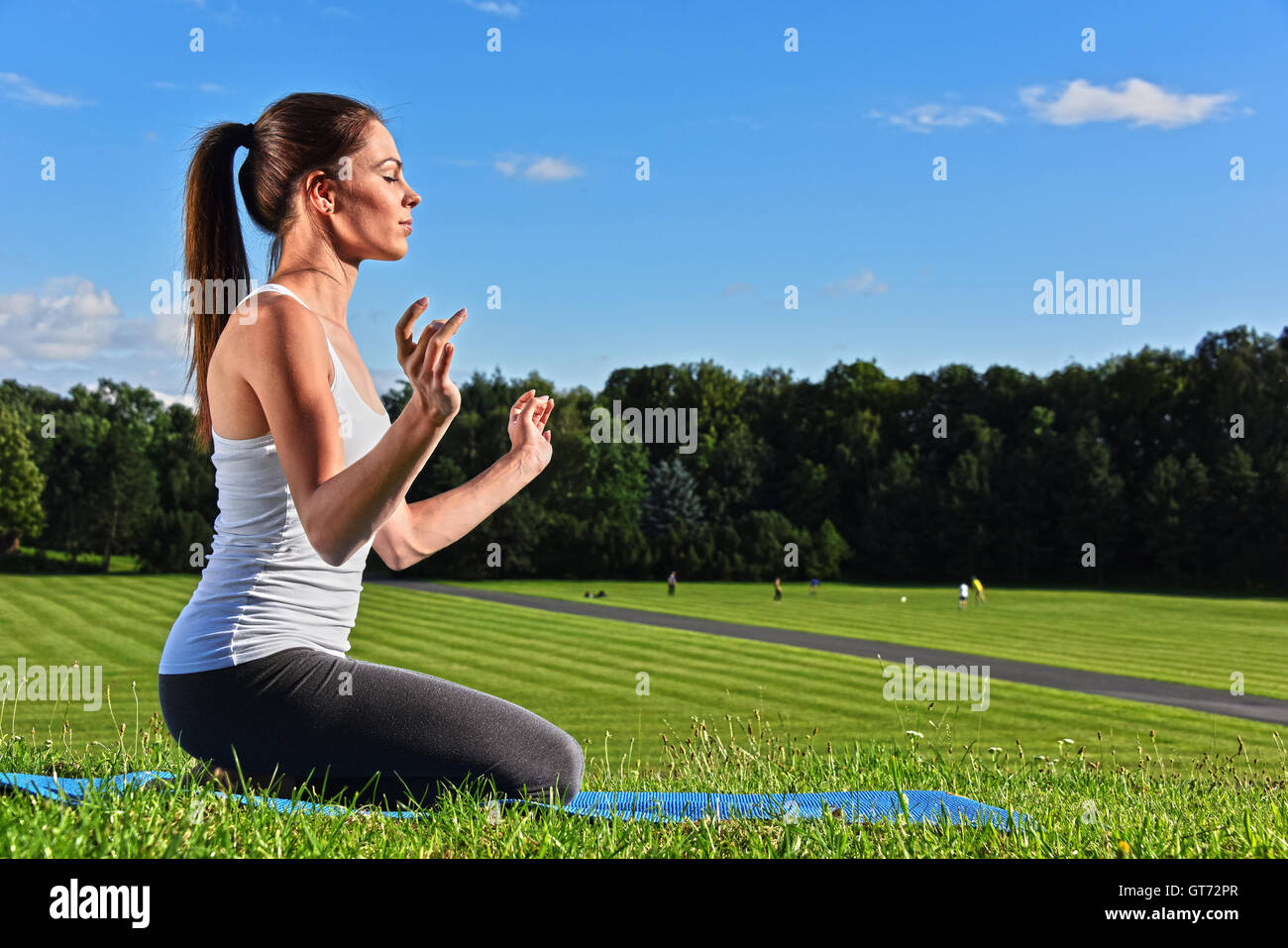 Junge Frau während der Yoga-Meditation im Park. Stockfoto