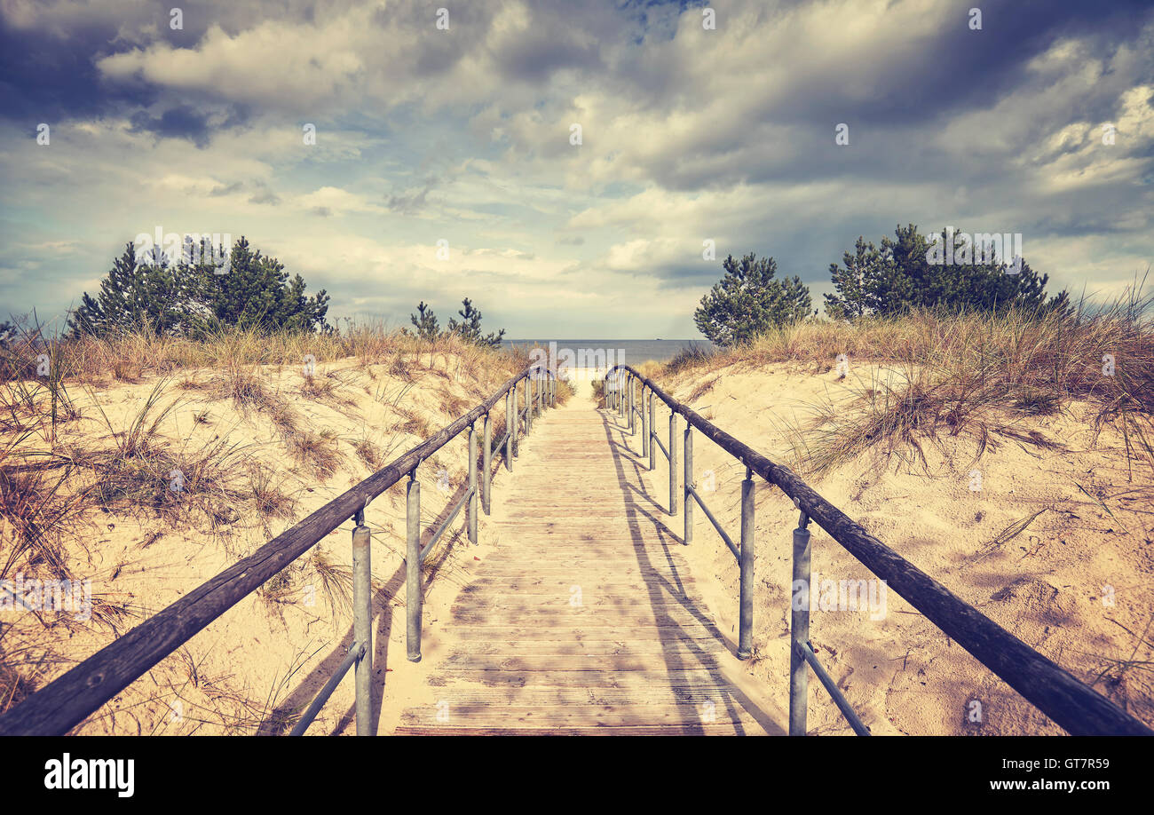 Vintage getönten Holz Wanderweg führt zu einem Strand an einem regnerischen Tag. Stockfoto