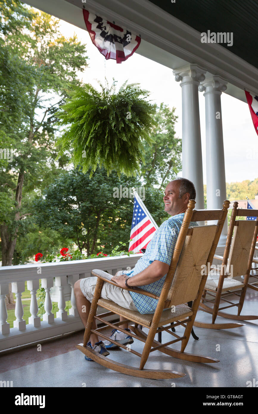 Glücklich Mitte Alter Mann auf Holz Schaukelstuhl auf der Terrasse sitzen  und die entspannende Natur und genießen Sie die 4. Tag o anzeigen  Stockfotografie - Alamy