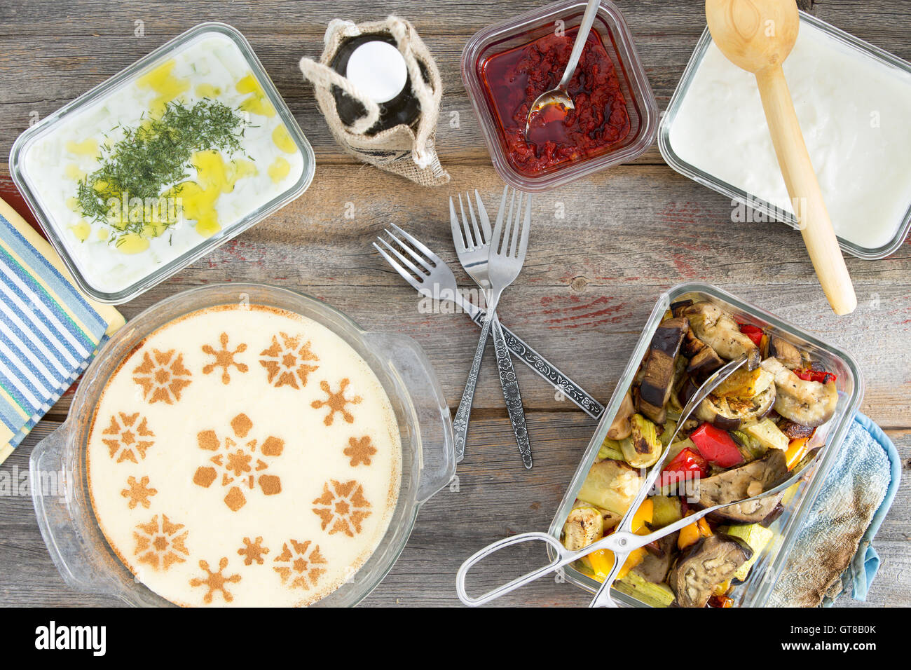 Leckeres Picknick mit gegrilltem Gemüse, Tzatiki, Joghurt mit Dill, Pfeffer, Paste und einem dekorativen milchig Grieß-Dessert Stockfoto