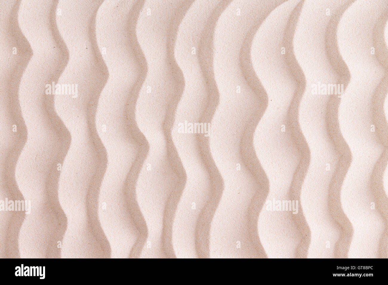 Dekorative gemusterten goldenen Strand Sand Hintergrund mit wellenförmigen Linien erinnern an die Wellen im Meer in einem nautischen oder marine Stockfoto