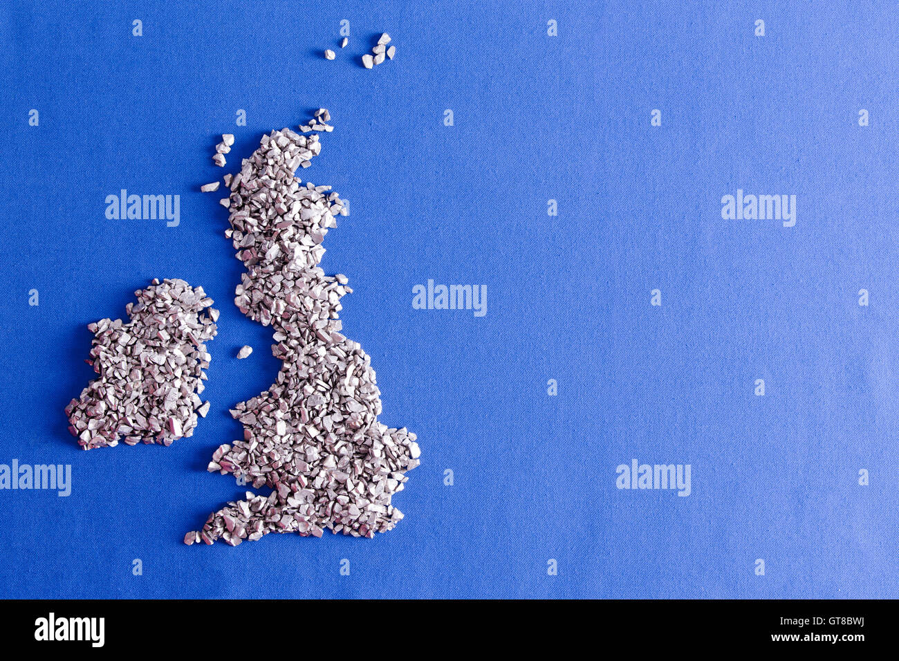 Konzeptionelle Karte von Großbritannien und Irland gebildet von silbernen Ziersteine über einem blauen Textil-Hintergrund Stockfoto