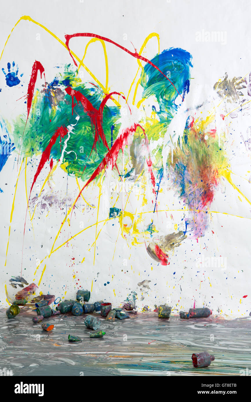 Verstreuten Lack Dosen unter einer modernen abstrakten Kunstwerken in hellen Farben gemalt auf einer weißen Wand in einem Ausdruck der creativi Stockfoto