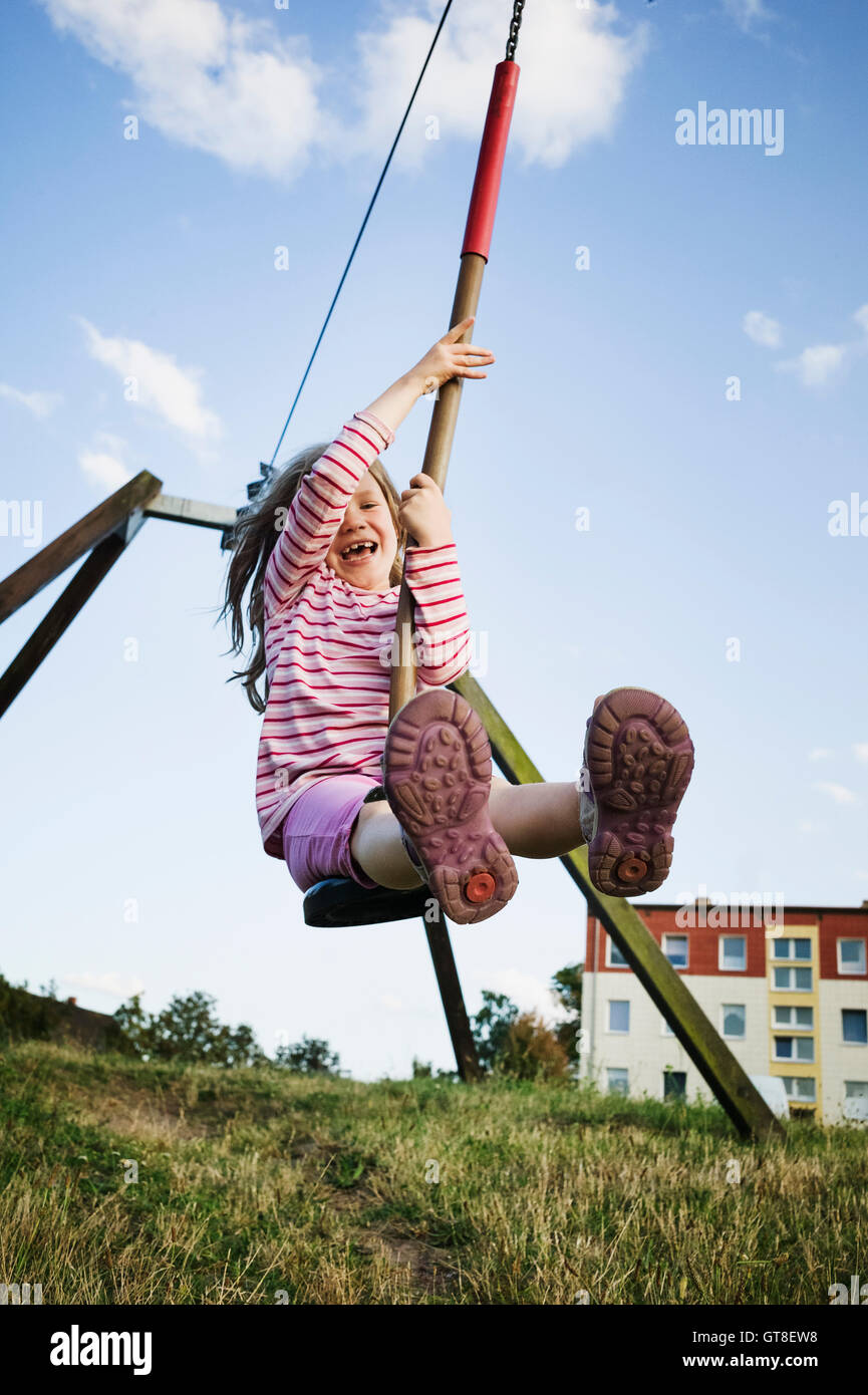 5 Jahre altes Mädchen spielen mit einer Seilrutsche an einem sonnigen Abend, Deutschland Stockfoto