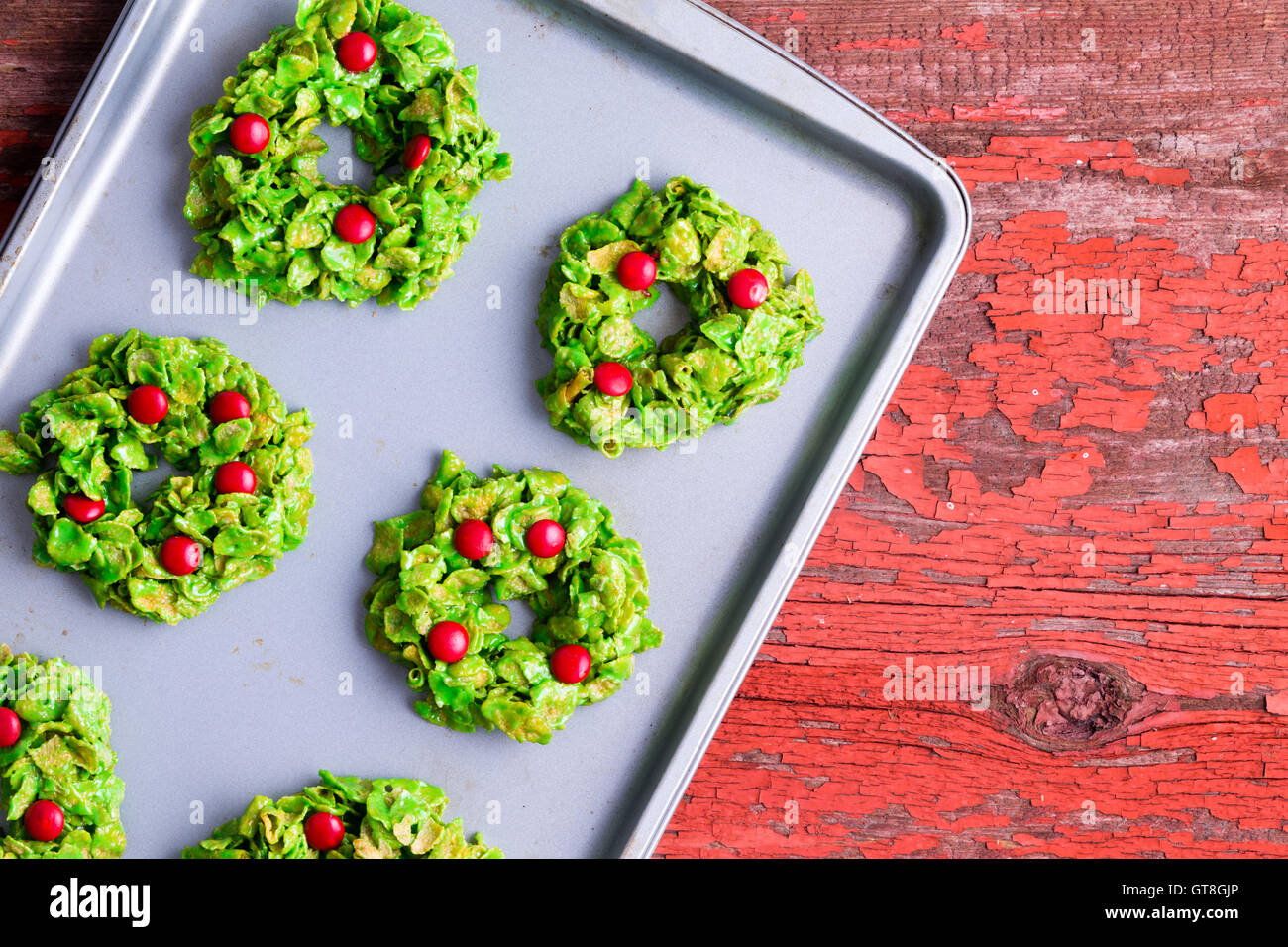 Frisch gebackenen Weihnachtsplätzchen Kranz mit bunten grünen und roten Cornflakes und Kühlung auf ein Metall Backblech auf Süßigkeiten gemacht ein Stockfoto