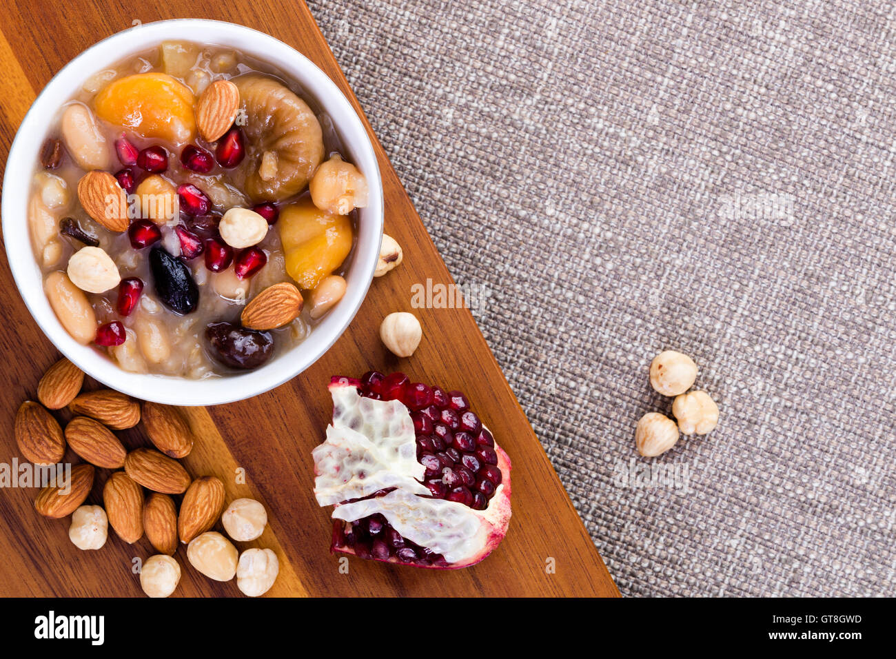Noahs Essen oder Ashure, eine Spezialität türkische süße Getreide Pudding, serviert mit Haselnüssen, Mandeln und Granatapfel Samen, overhead Stockfoto