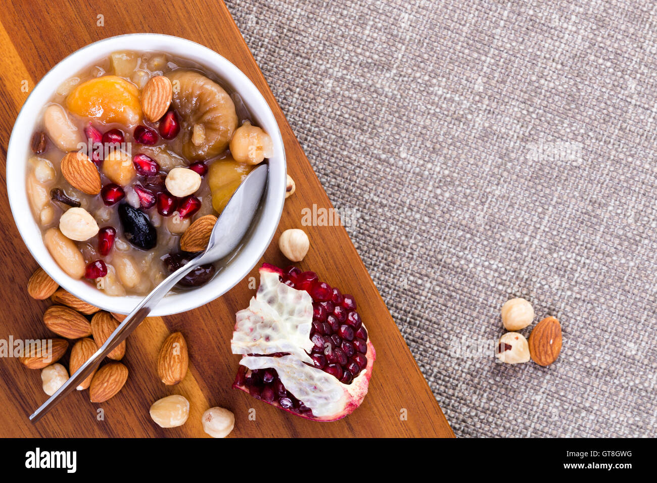 Spezialität Noah der Pudding oder Türkisch Ashure, süße Getreide Dessert, serviert mit Granatapfelkernen, Mandeln und Haselnüsse auf einem w Stockfoto