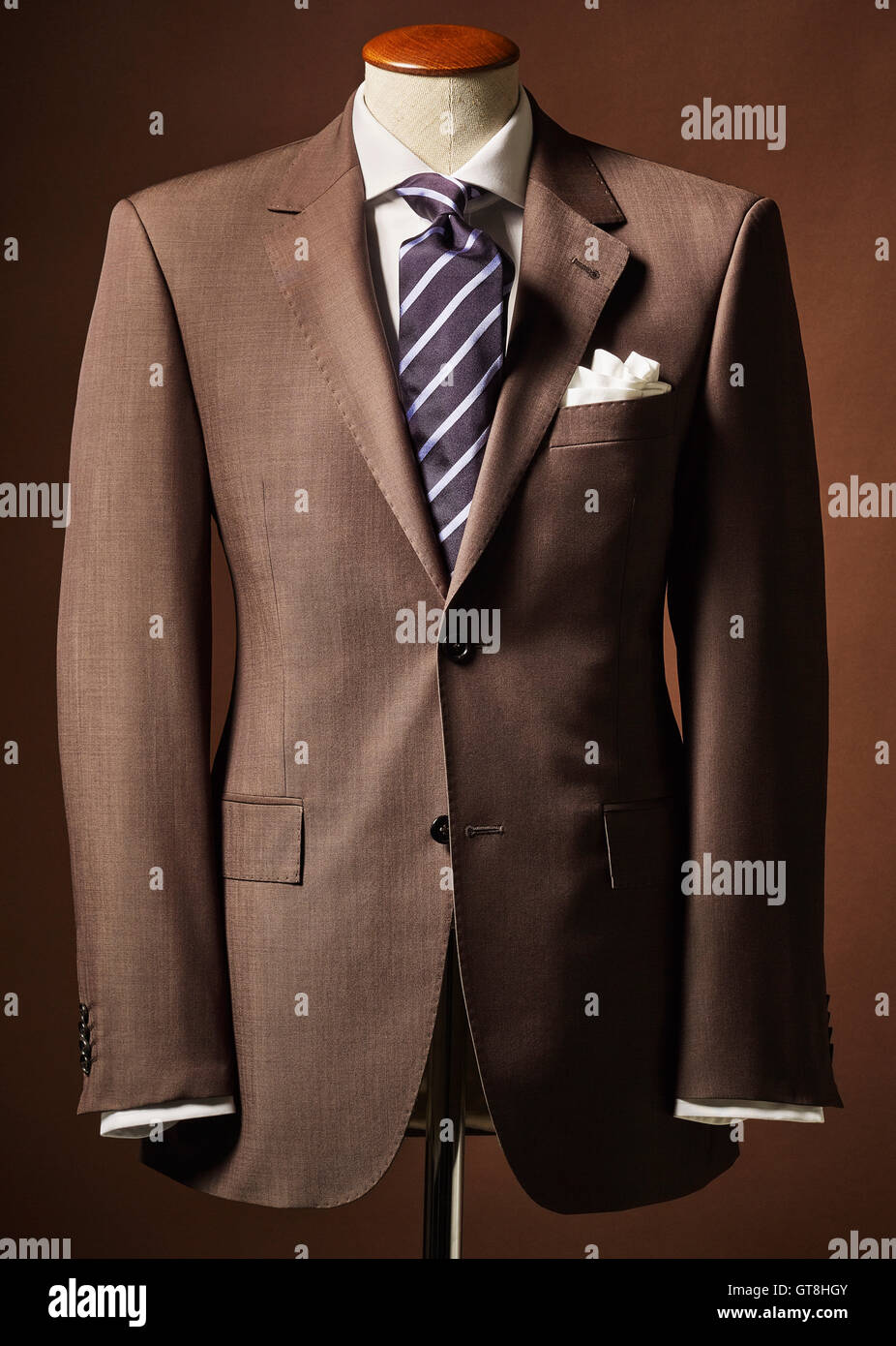 Braunen Anzugjacke auf Büste mit Taschentuch und Krawatte auf braunem Hintergrund Stockfoto