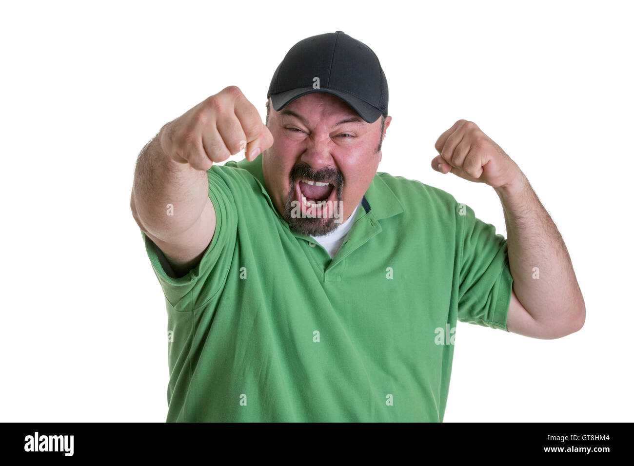 Taille bis aufgeregt Mann mit Spitzbart in grünen Hemd und Baseball-Kappe, die Fäuste in die Luft halten und feiern Team im Studio zu gewinnen Stockfoto