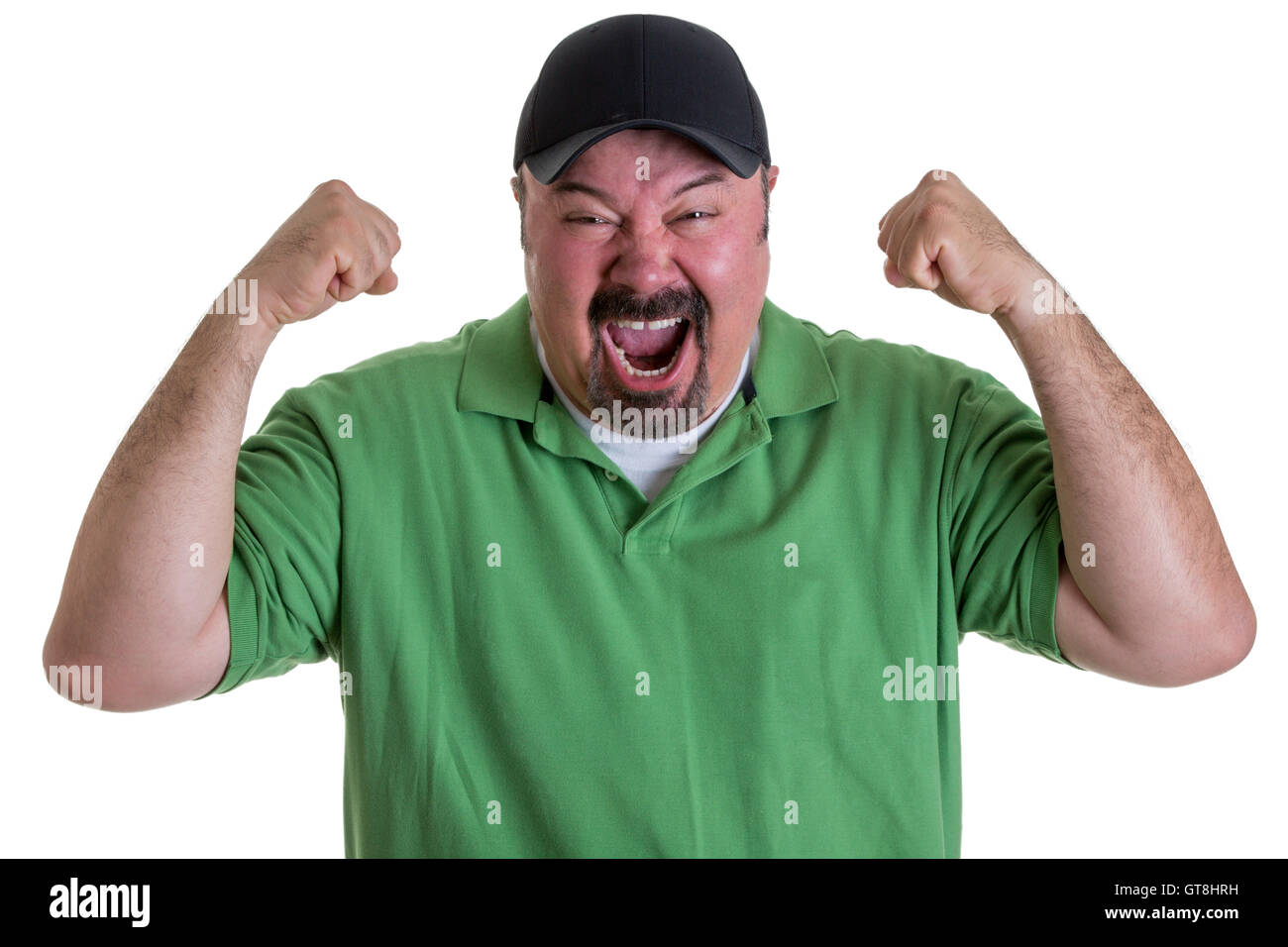 Taille bis aufgeregt Mann mit Spitzbart in grünen Hemd und Baseball-Kappe, die Fäuste in die Luft halten und feiern Team im Studio zu gewinnen Stockfoto