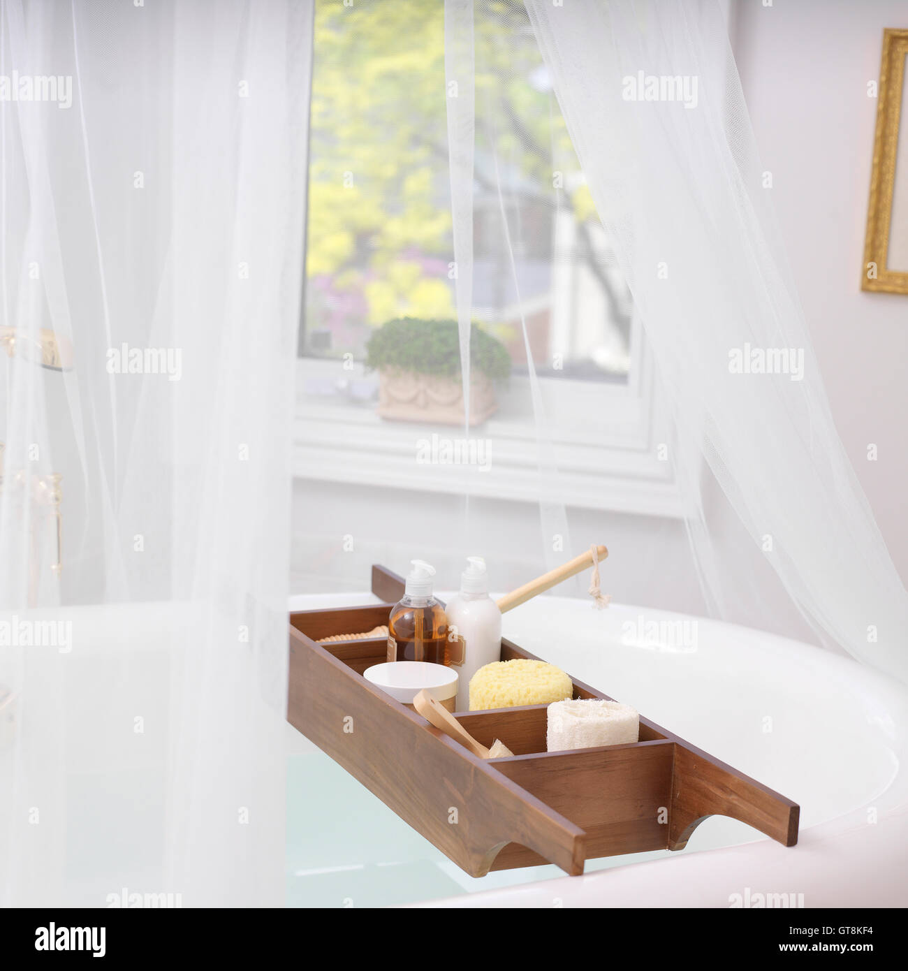 Bath Caddy auf Badewanne voller Bad Gegenstände Stockfoto
