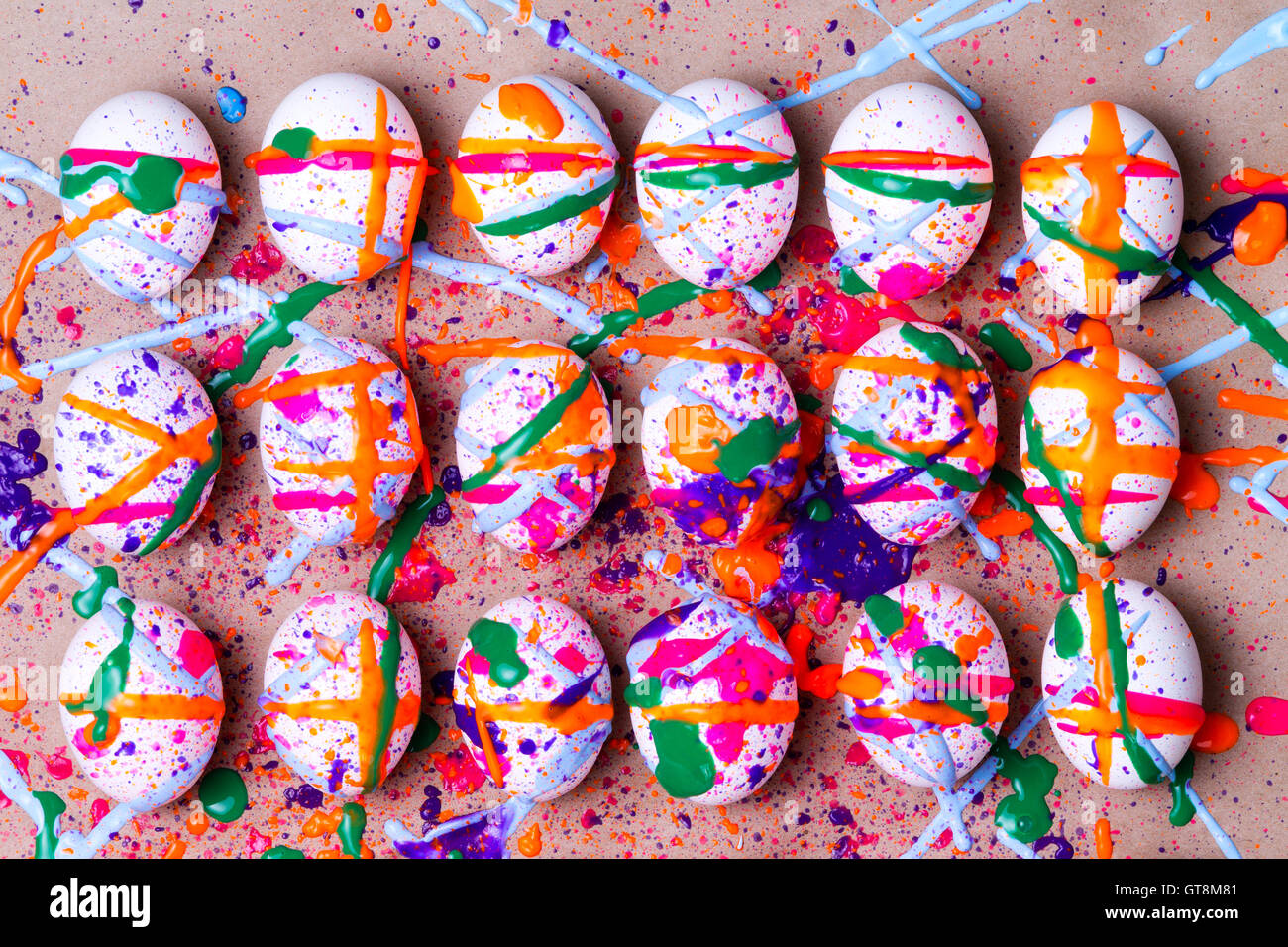 Bunte Oster-Projekt von Hand bemalten Eiern mit eine zufällige Splatter lebendige Farbe in rosa, orange, grün und blau splatte Stockfoto