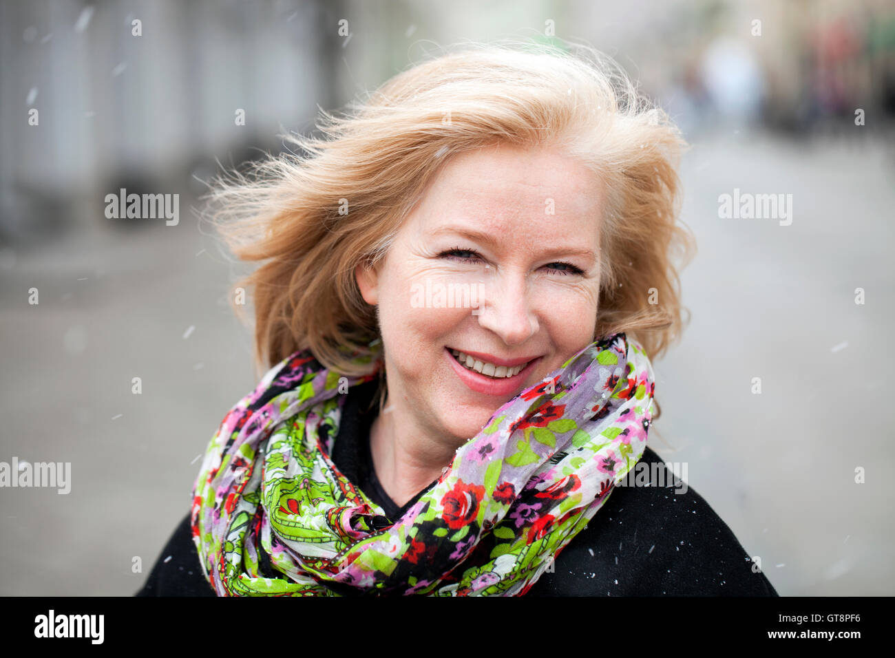 Unerwarteten Schneefall in Mitte April, happy Portrait einer älteren Frau auf der Straße Stockfoto