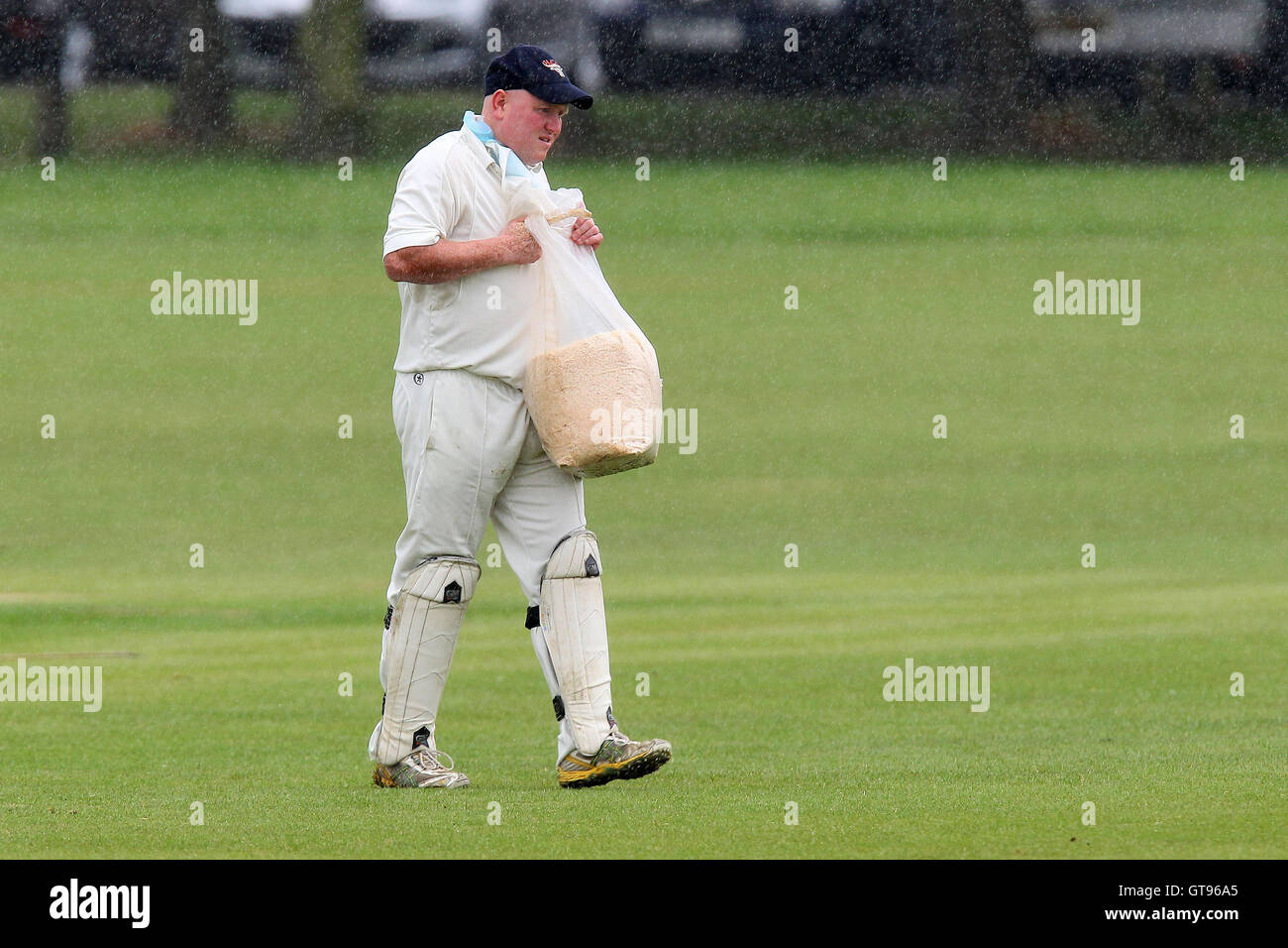 Paul Murray von unterstützt trägt einen Beutel mit Sägemehl, wie Regen Verzögerungen - unterstützt CC Vs Romford & Gidea Park CC - Essex Cricket League in Harrow Lodge - 15.06.13 spielen Stockfoto
