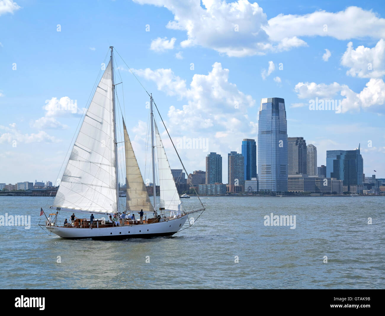 Ein Segelboot auf dem Wasser mit einer Stadt hinter Stockfoto